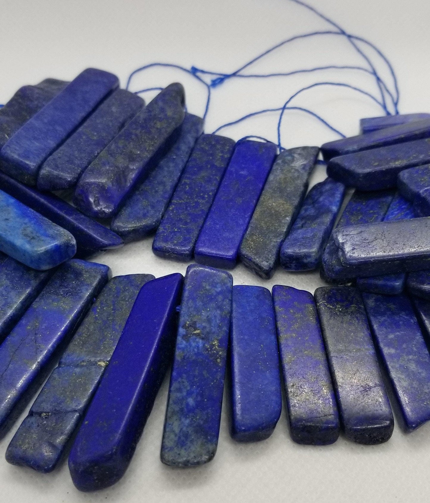 4 pointes de cristal de lapis-lazuli naturel, teintées, percées sur le dessus, semi-mates, semi-polies, polies grossièrement, 20~65x7~15x6~10mm, trou 2mm