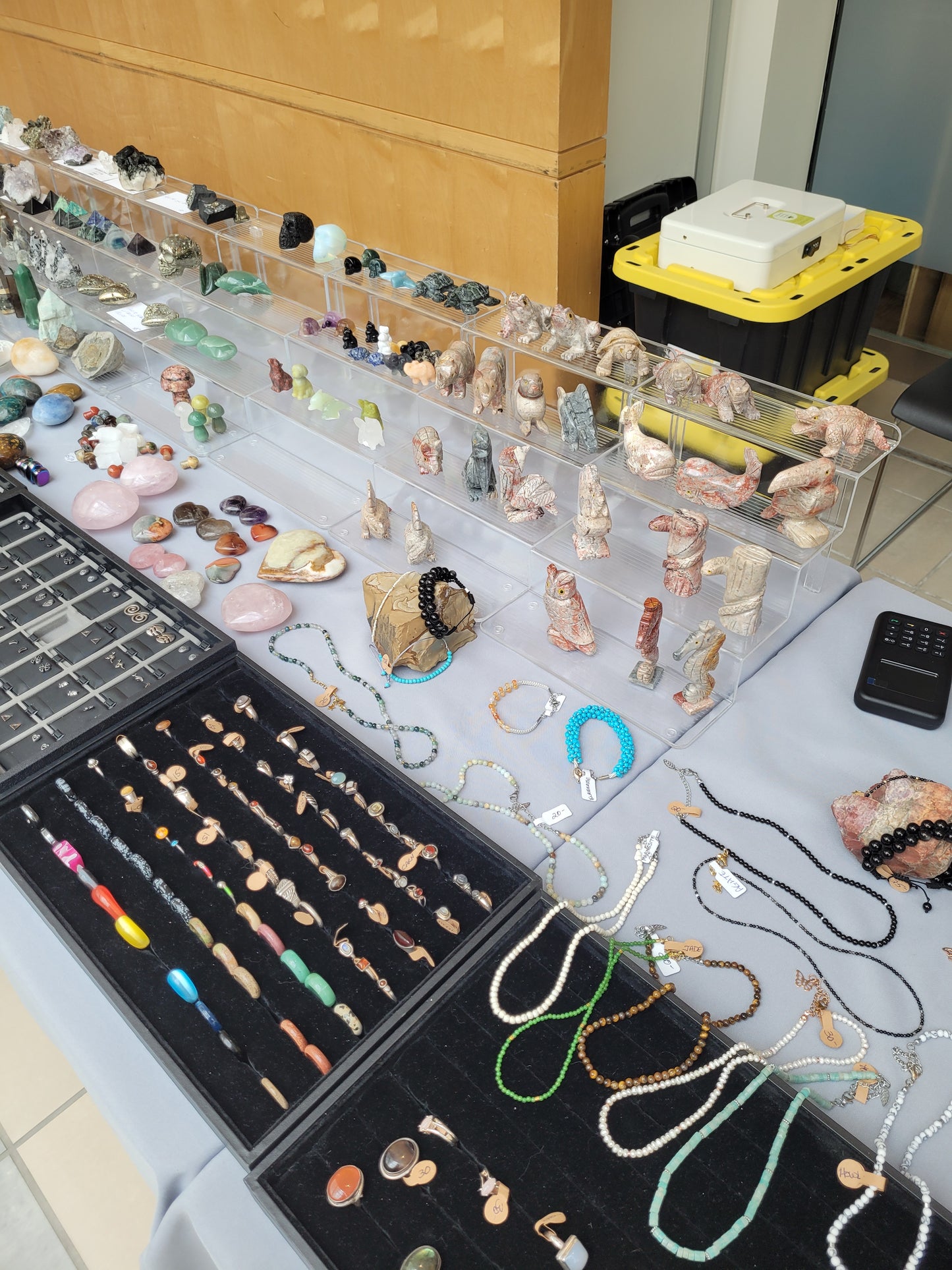 Jewelry display with necklaces and pendants on a table next to a laptop.
