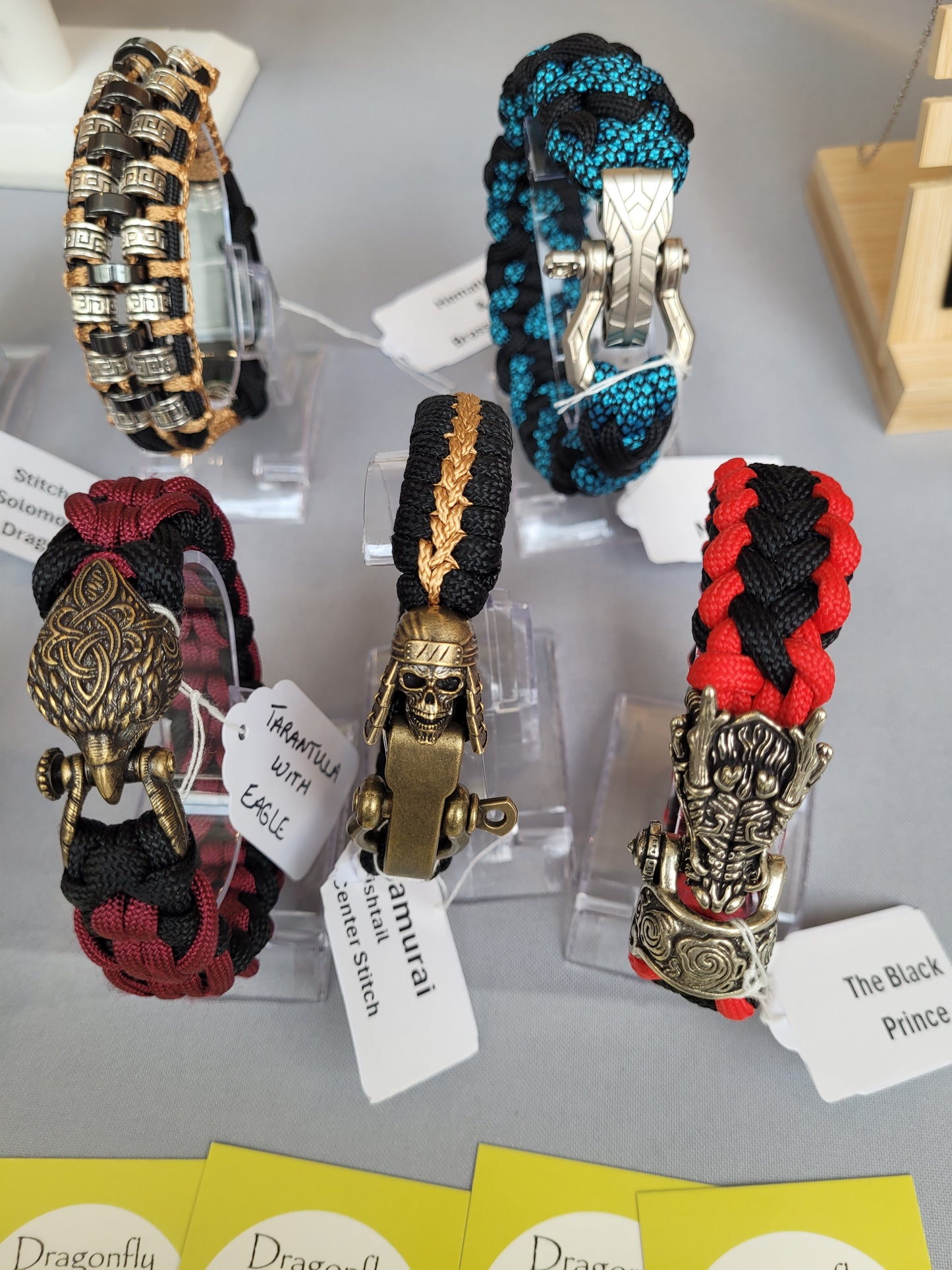 Paracord bracelets with metal clasps on display with name tags.