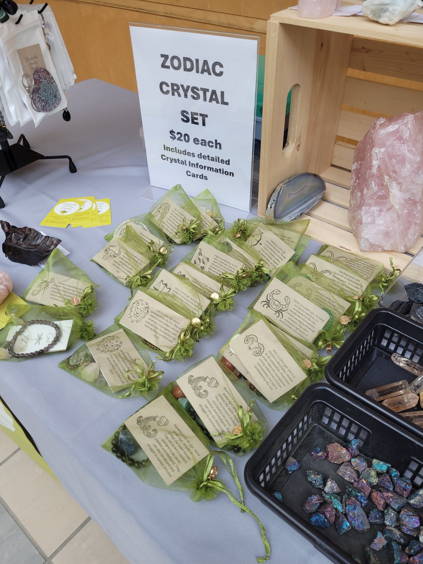 Zodiac crystal set with cards on a table, next to a wooden crate and crystals.