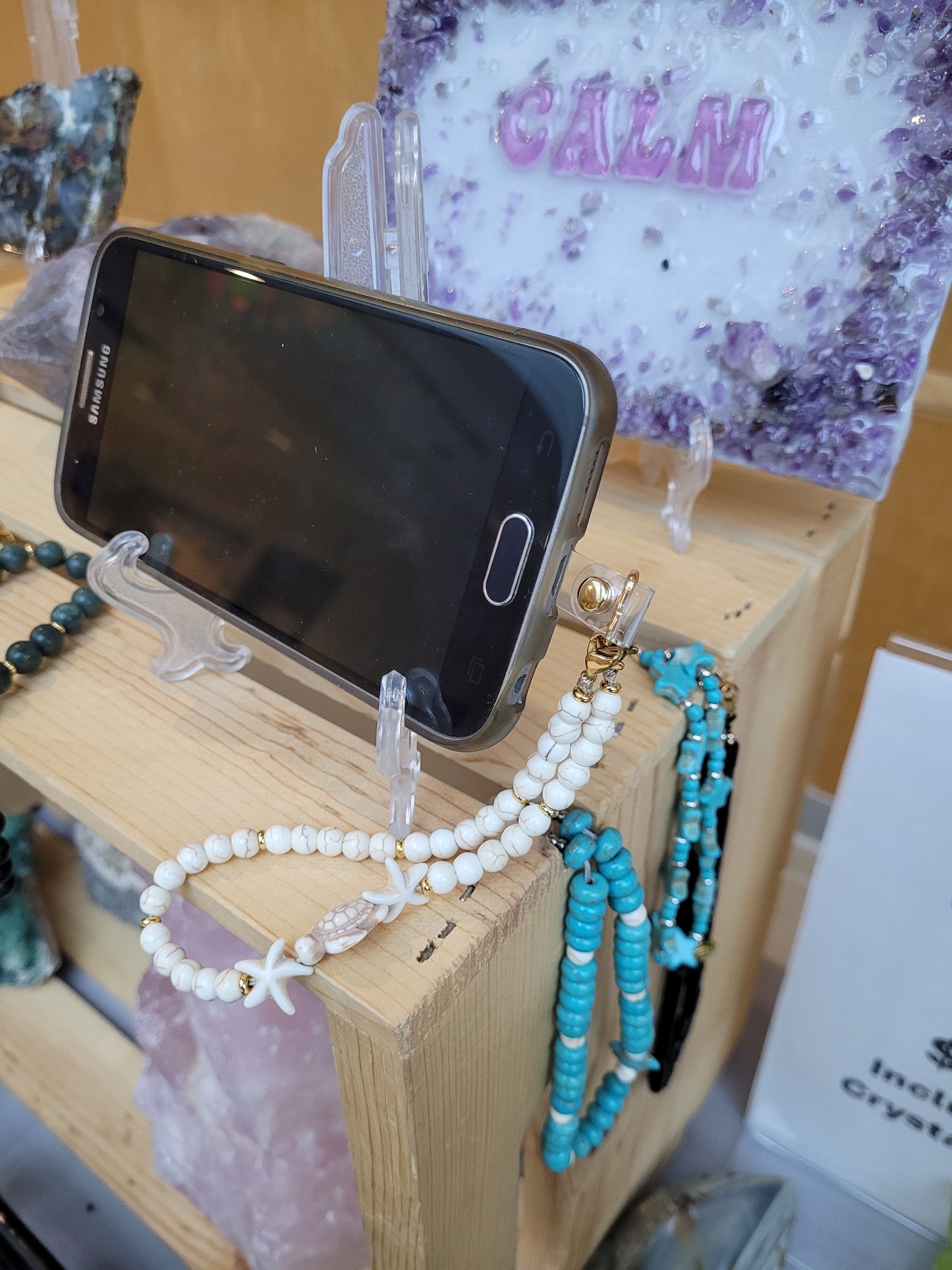 Crystal Phone straps  on a wooden crate with crystal art.