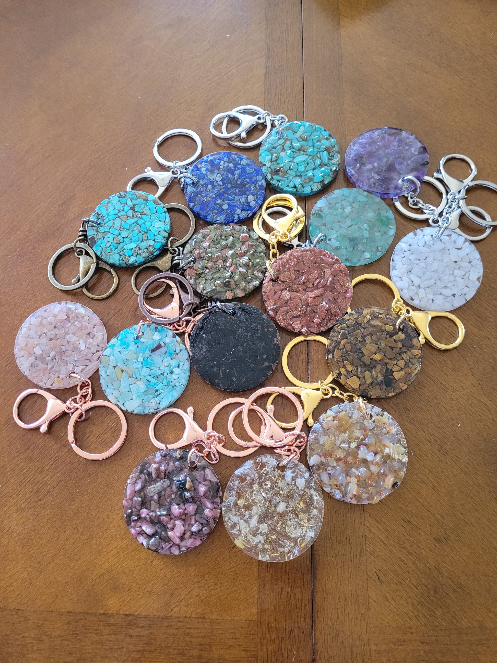 Collection of crystal keychains on a wooden surface